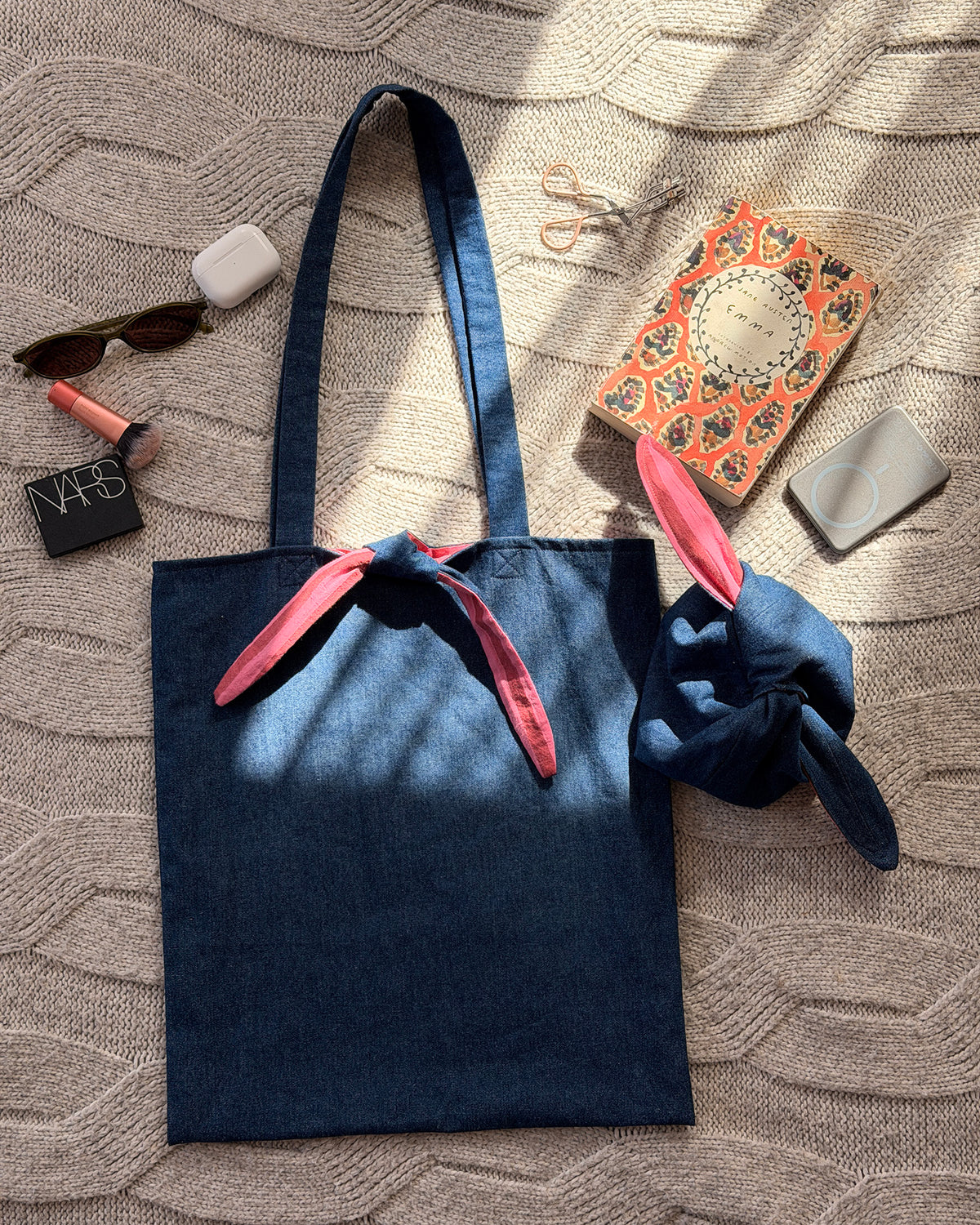 A dark denim blue fabric tote bag with long shoulder straps with pink and maroon striped lining. Organiser Tie Up Bag too. Y2K aesthetic.